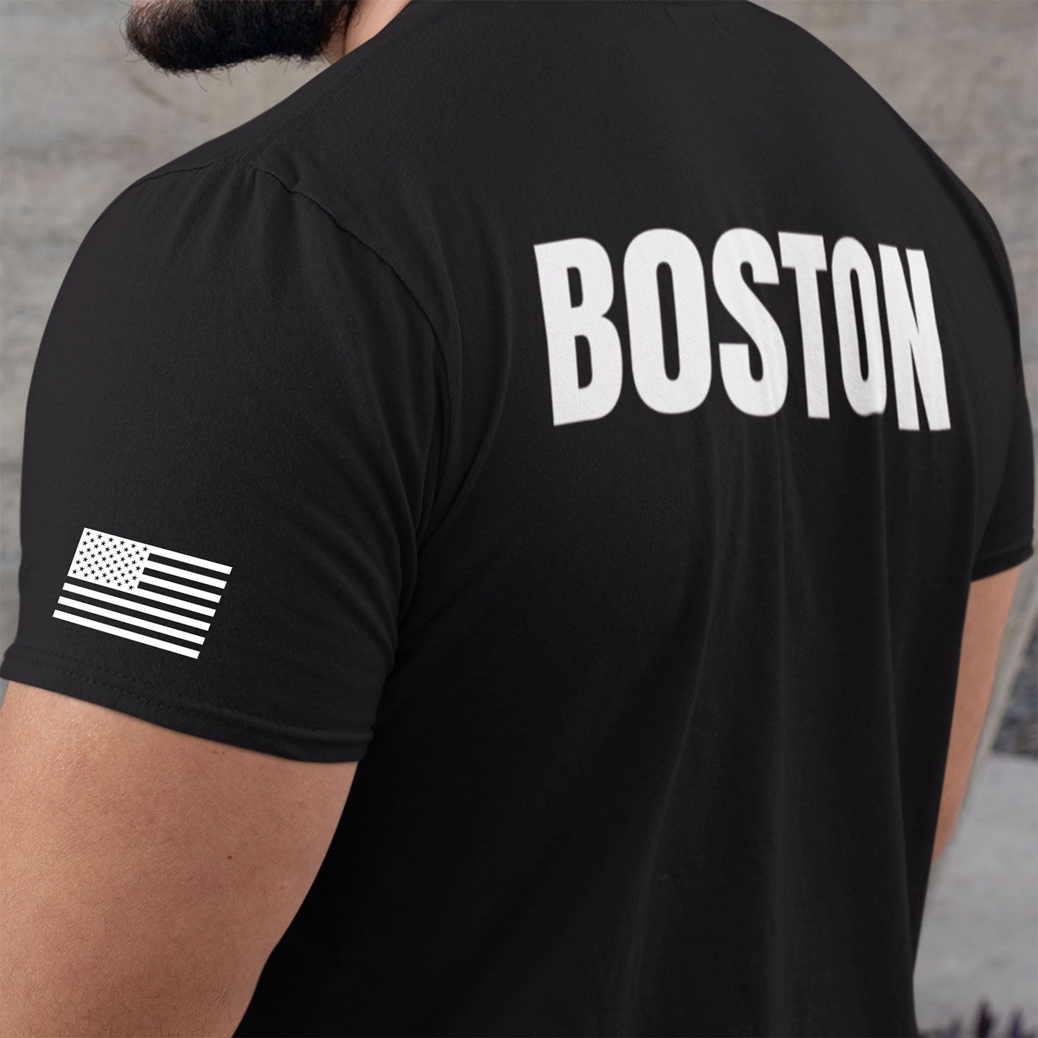 Black t-shirt with 'BOSTON' printed on the back, worn by a person.